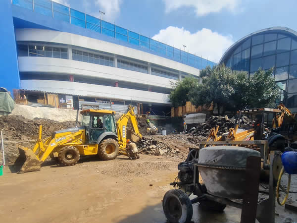 Muestra equipo de trabajo y maquinas trabajando en edificio.